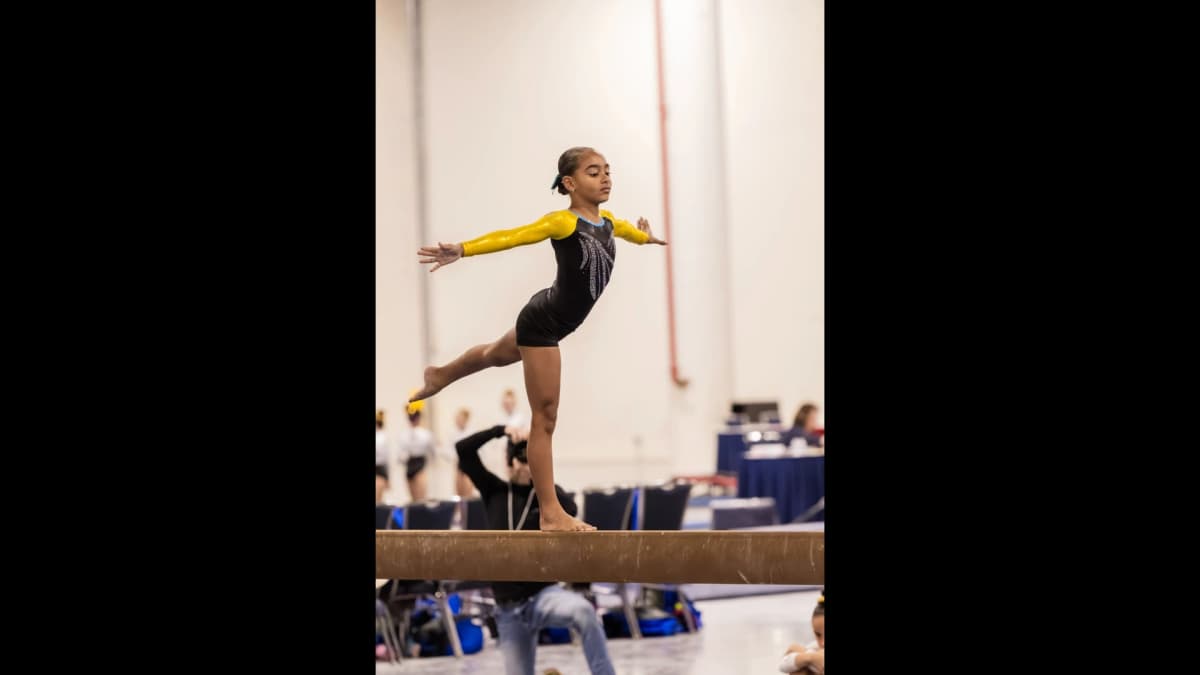 Gymnast performing balance beam routine in competition