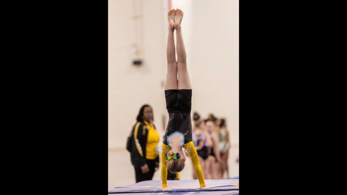 Elite gymnast performing advanced beam routine