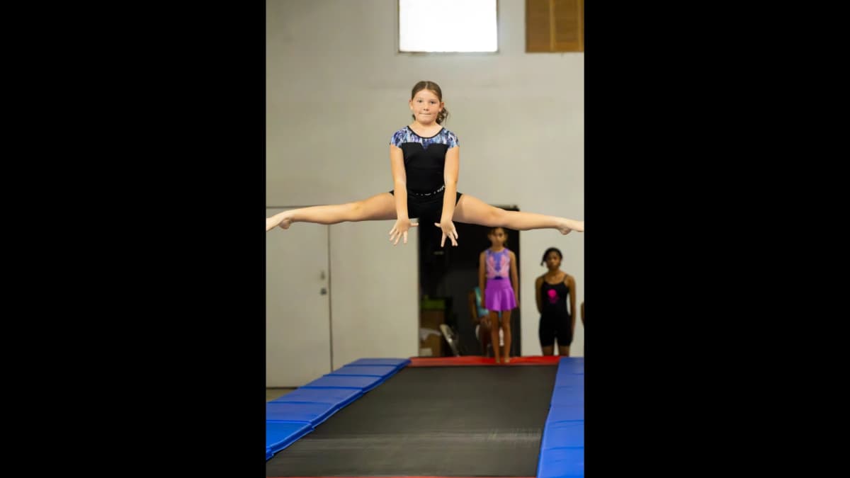 Gymnast practicing jump splits during training