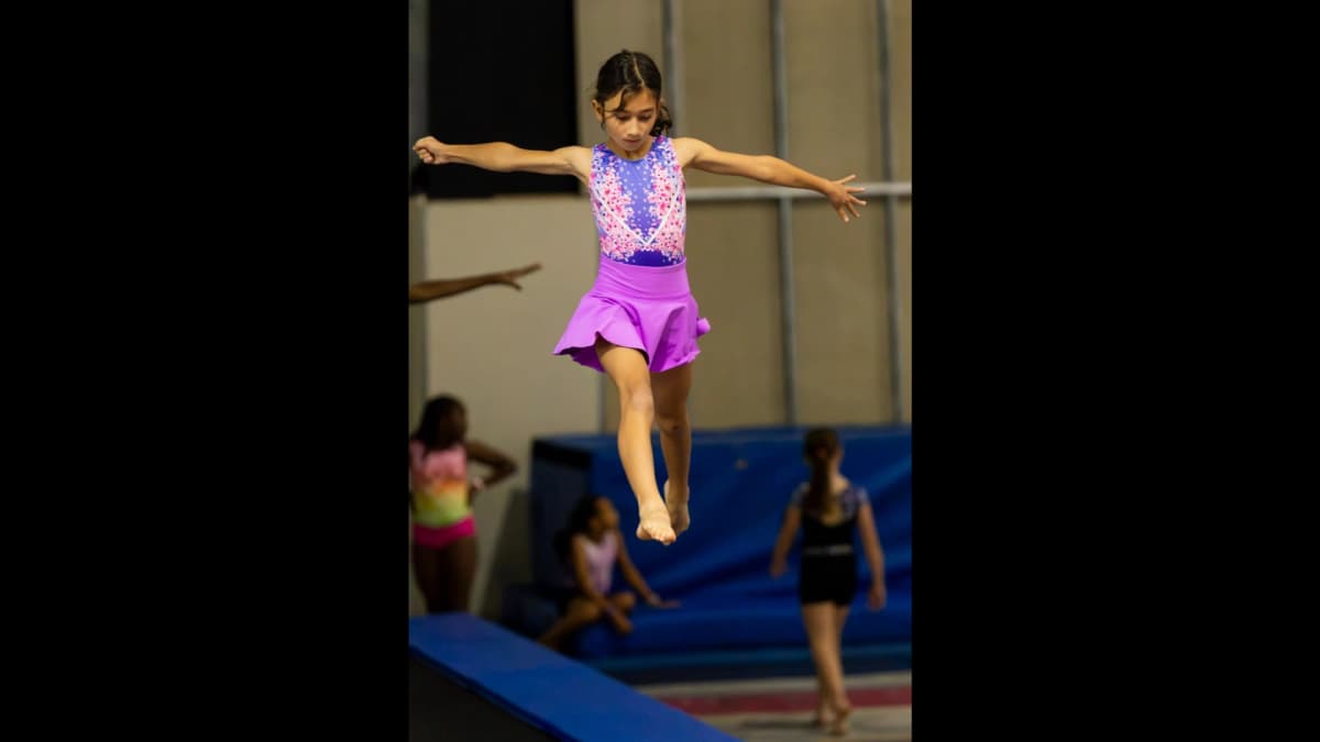 Gymnast practicing advanced jump split technique